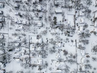 2026年1月25日、ミズーリ州コロンビアの住宅街に数インチの新雪が積もった航空写真。1月24日、冬の大嵐が雪と冷たい雨をニューメキシコ州からノースカロライナ州にもたらし、米国北東部を横切り、何百万ものアメリカ人に停電、交通機関の混乱、骨も凍る寒さの脅威をもたらした。この暴風雨システムは国の南西部と中部地域を壊滅させた後、冷たい空気が国中を移動するにつれて、人口の多い中部大西洋岸の州と北東部の州にも影響を及ぼし始めた。
